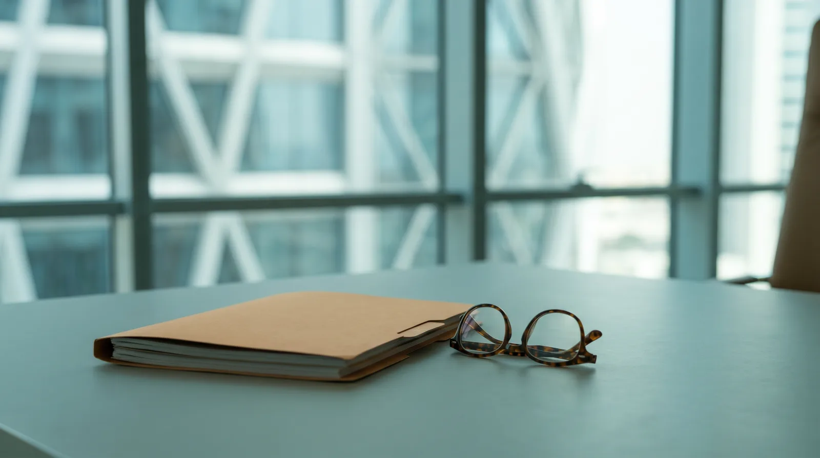 Quiet, professional desk with a closed legal folder against a softly blurred modern UAE building, conveying a neutral and respectful tone for a guide on abortion law.