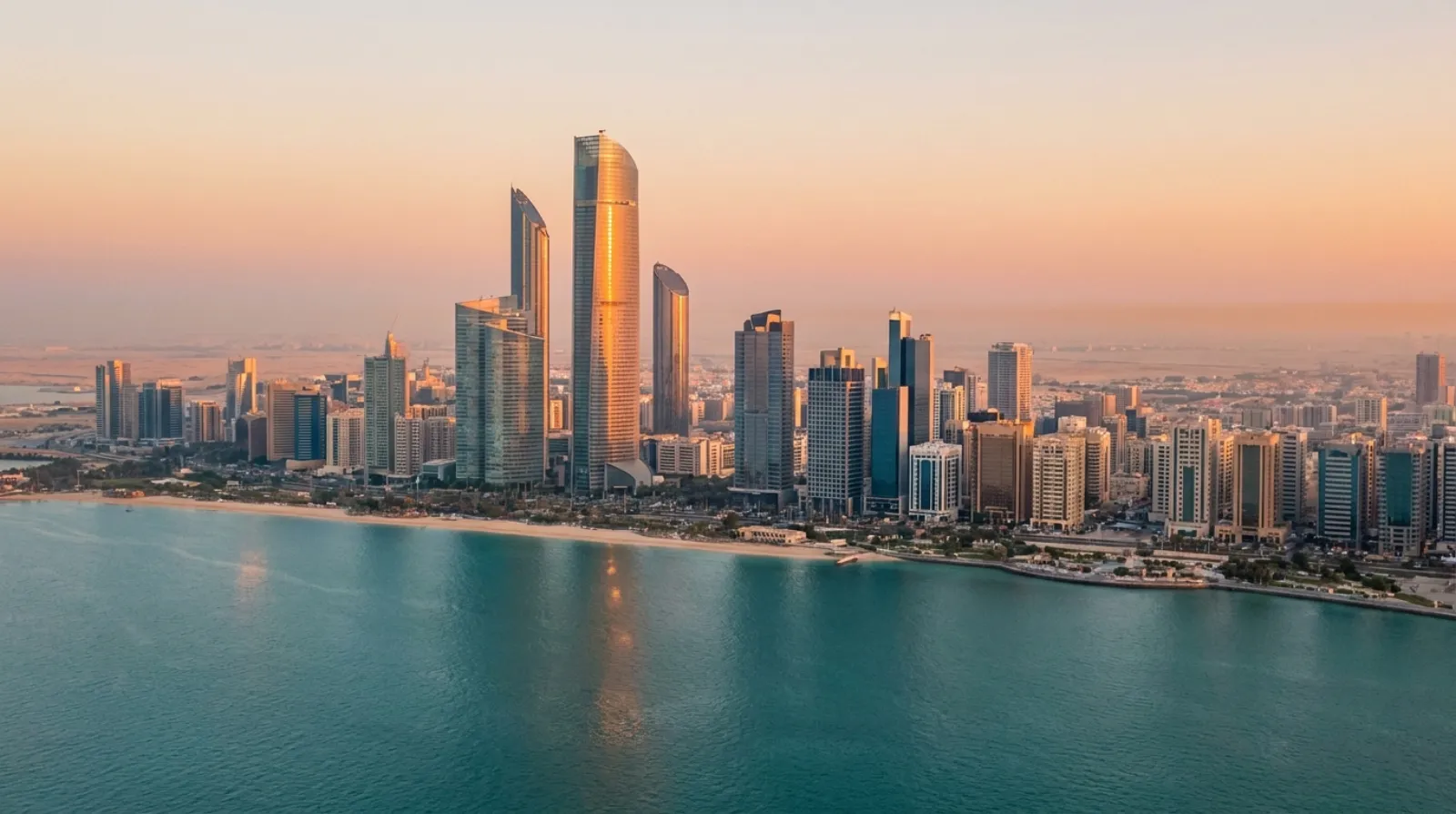 Aerial view of Abu Dhabi's modern skyline and Corniche waterfront at dusk