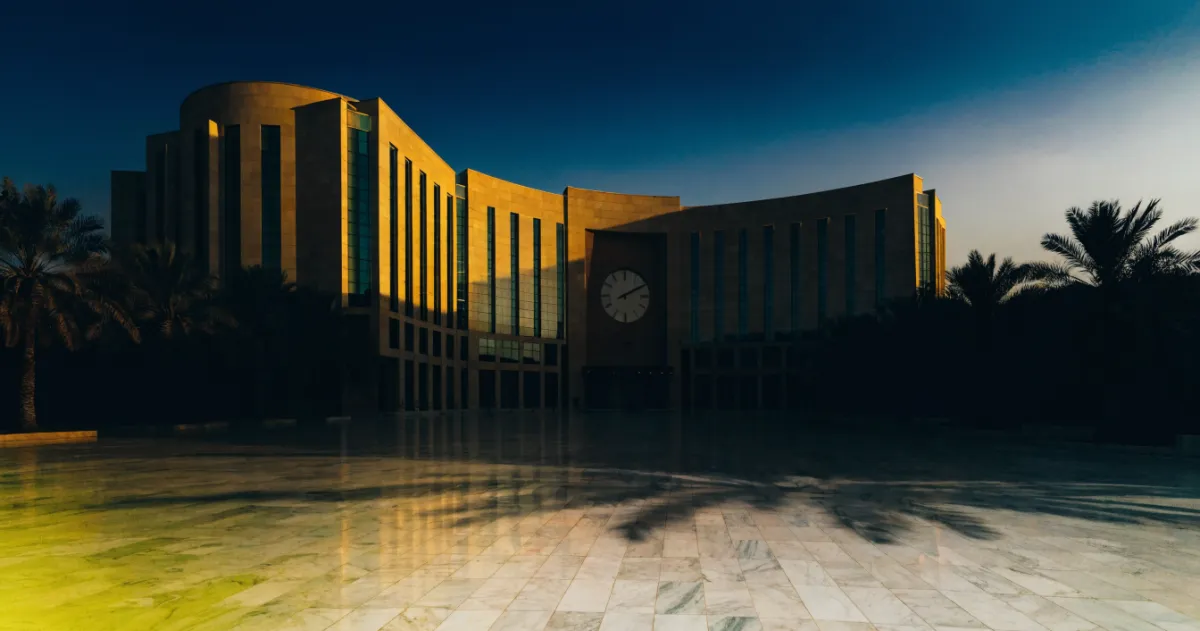 Modern Dubai courthouse building exterior at early morning with clock and empty forecourt