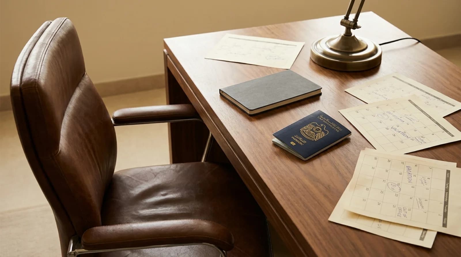 Empty office chair with a folded UAE passport and notebook — UAE annual leave entitlements